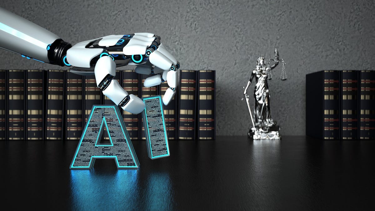 A robot hand stacks the letters 'AI' in front of law books and a statue of blind justice.